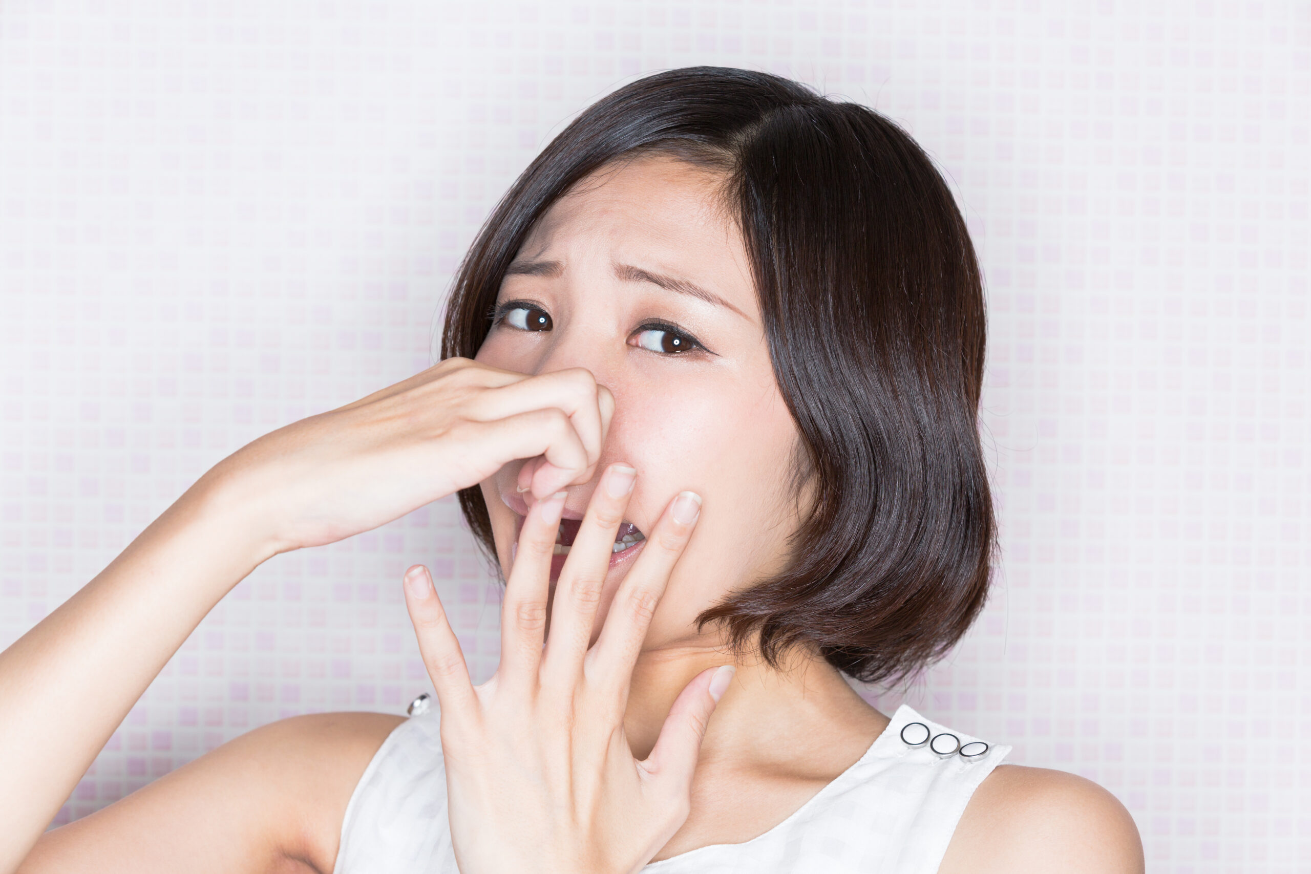根管治療による口臭に鼻をつまむ女性